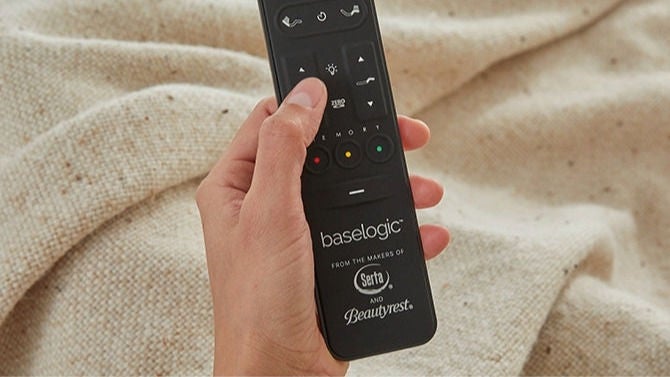 Hand holding remote with visible branding