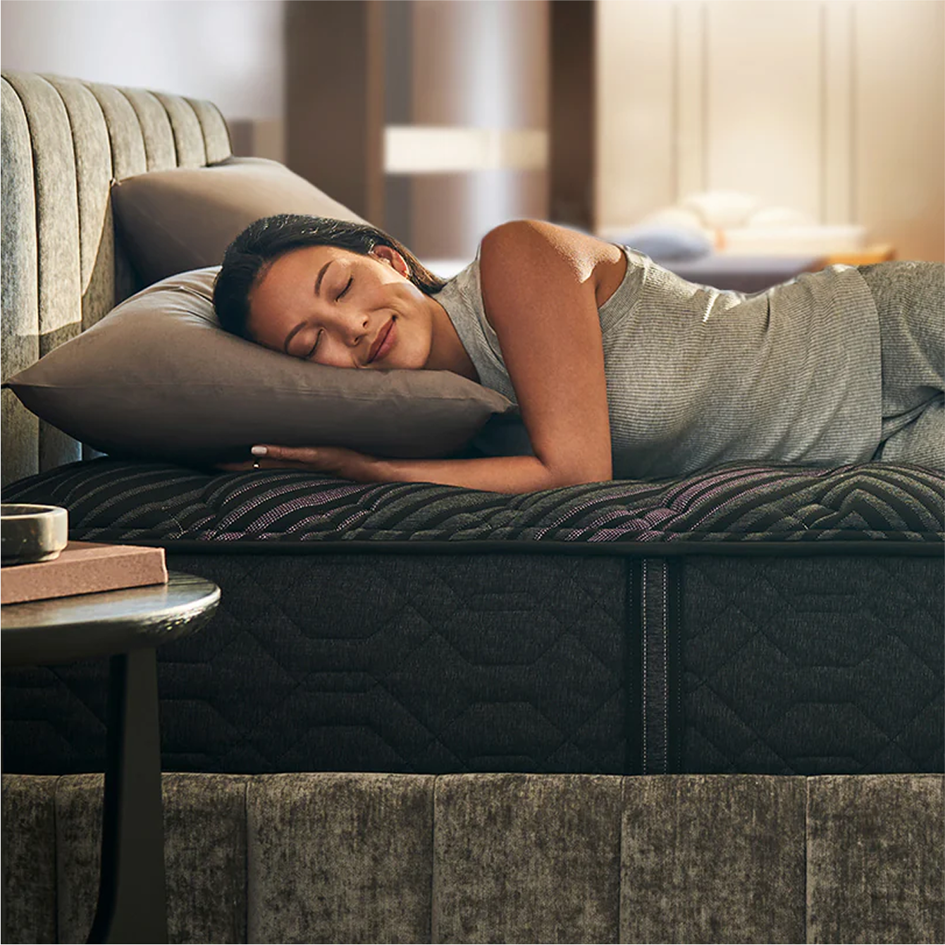 Woman resting on modern mattress in bedroom