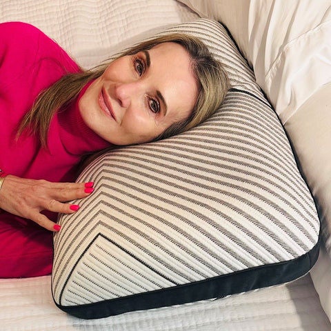 Chevron-patterned ergonomic pillow on bed