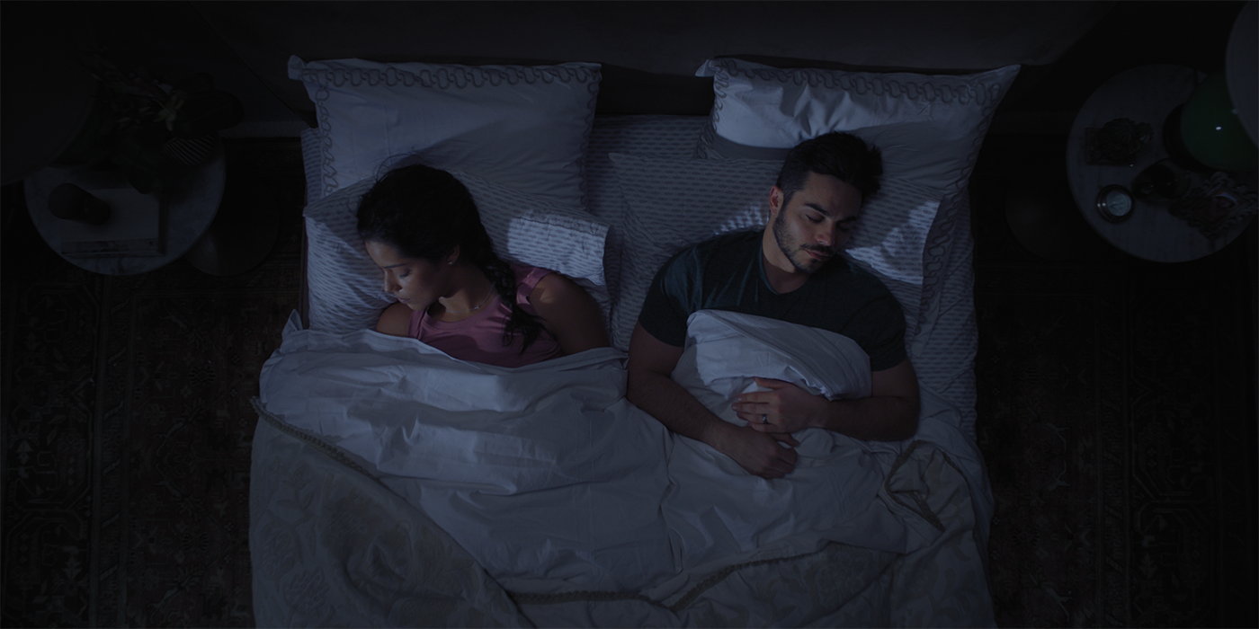 Couple sleeping in dimly lit bedroom