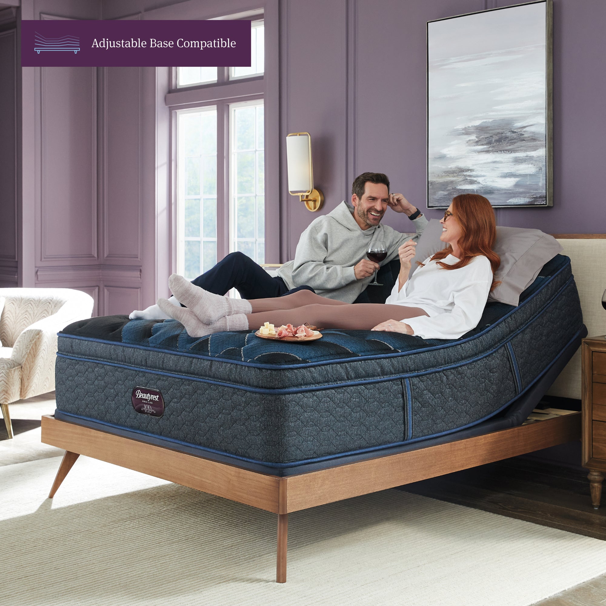 Man and woman laying in an upright position on a Beautyrest World Class Plush Pillowtop mattress elevated on an adjustable base